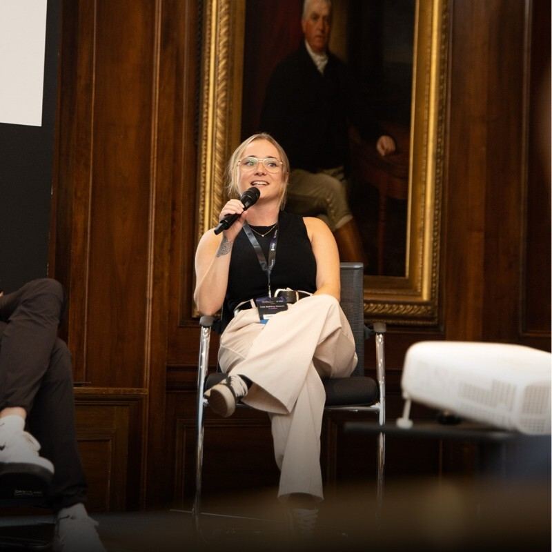 Sophie Brannon speaking on a panel, microphone in hand